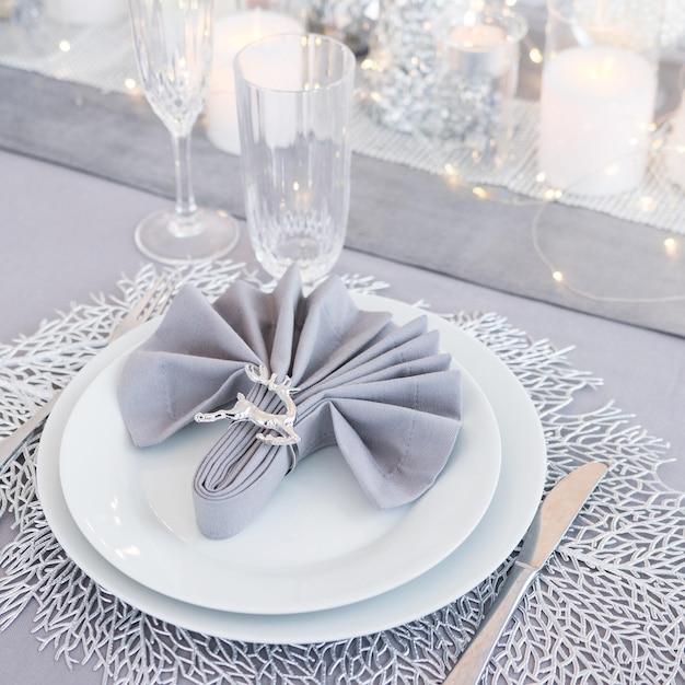 Beautiful table setting with Christmas decorations Silver colors