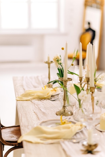 사진 텍스트를 위한 공간이 있는 색상 배경에 신선한 해바라기가 있는 아름다운 테이블 설정실내 꽃 장식이 있는 아름다운 부활절 테이블 설정