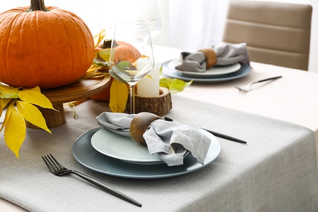 Bella tavola con zucche e foglie d'autunno nella sala da pranzo