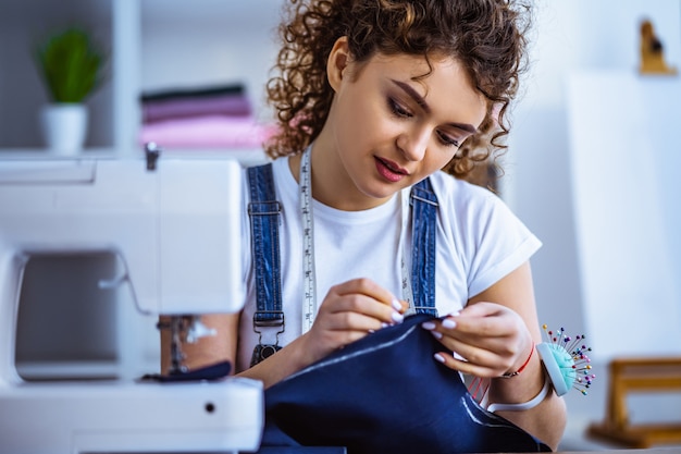 The beautiful tailor working near the sewing machine