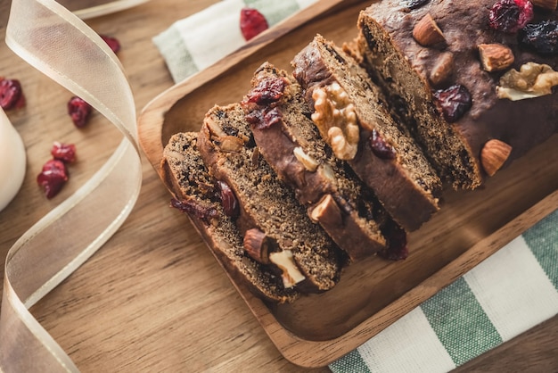 Beautiful tasty homemade mixed nut dried fruit cake on wooden table