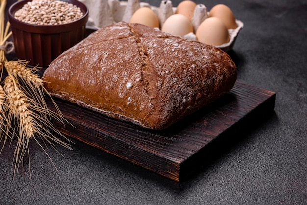 Beautiful tasty squareshaped brown bread on a dark concrete background Baking bread at home