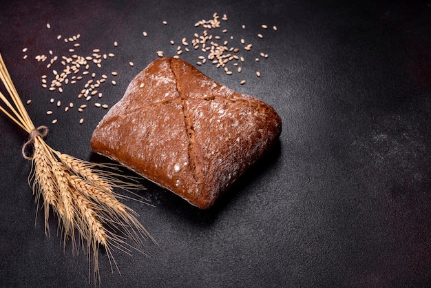 Beautiful tasty squareshaped brown bread on a dark concrete background Baking bread at home