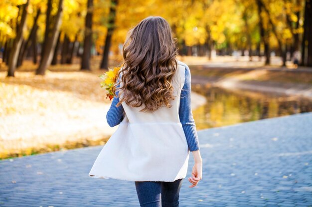 Beautiful teenage girl posing in autumn park