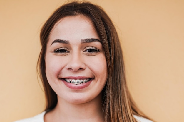 Beautiful teenage girl with dental braces smiling on\
camera