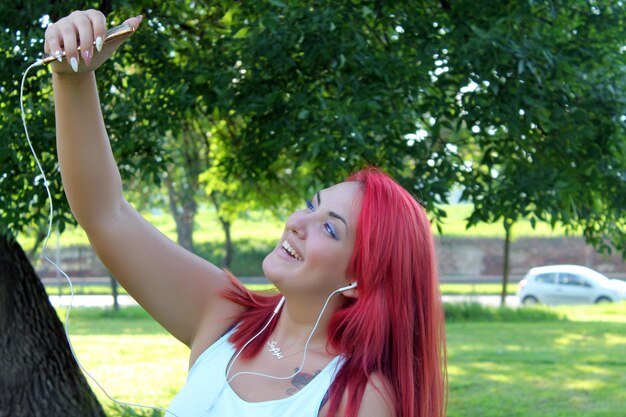 Beautiful teenage woman with red hair taking self portrait