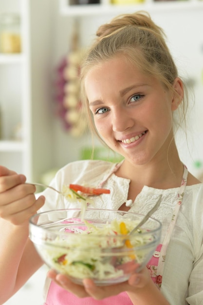 Beautiful teenager girl coocking on kitchen