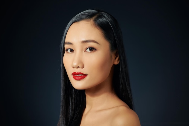 A beautiful tender girl with beautiful long dark hair in black background