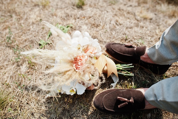 Beautiful tender wedding bouquet and groom shoes