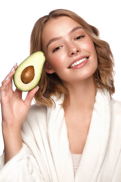 Beautiful tender young girl in a white coat with clean fresh skin posing in front of the camera. Beauty face. Skin care. Photo taken in studio on a white isolate background.