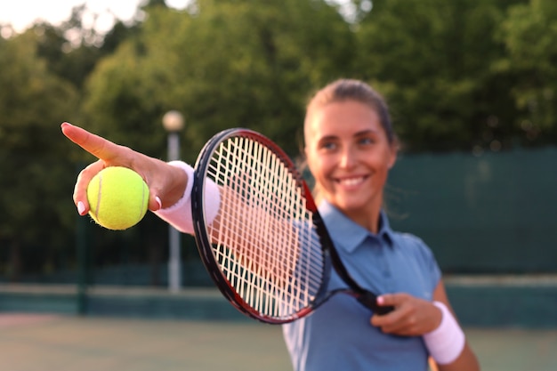 Bellissimo giocatore di tennis che serve la palla sul campo da tennis.