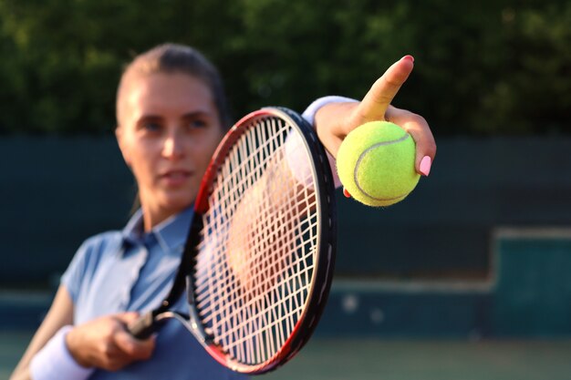 Beautiful tennis player serving the ball on the tennis court.