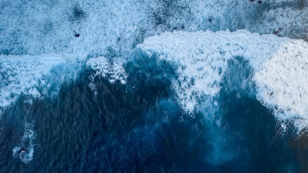 Beautiful texture of dark ocean waves with white foam drone\
filming breaking surf in indian ocean on