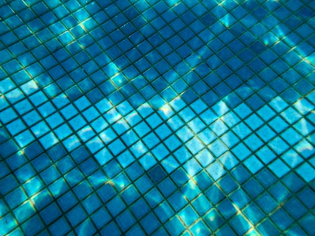 Photo beautiful texture of a small square ceramic tile with seams in a pool under blue water underwater