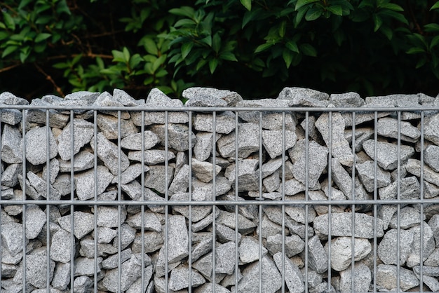 Photo a beautiful textured fence made of mesh and stones