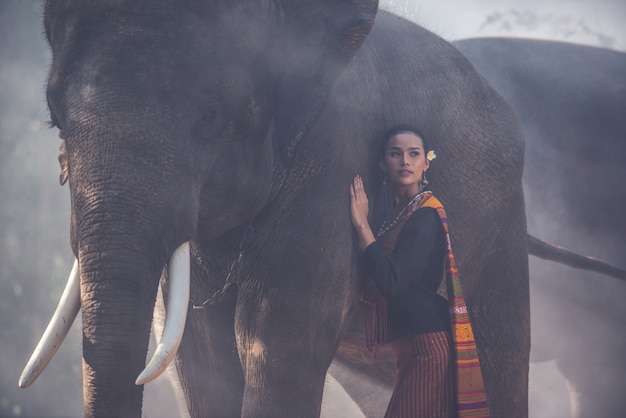 Bella donna tailandese che passa tempo con l'elefante nella giungla