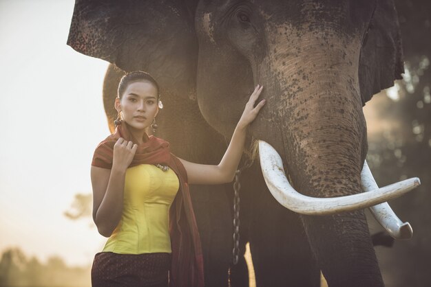 Bella donna tailandese che passa tempo con l'elefante nella giungla