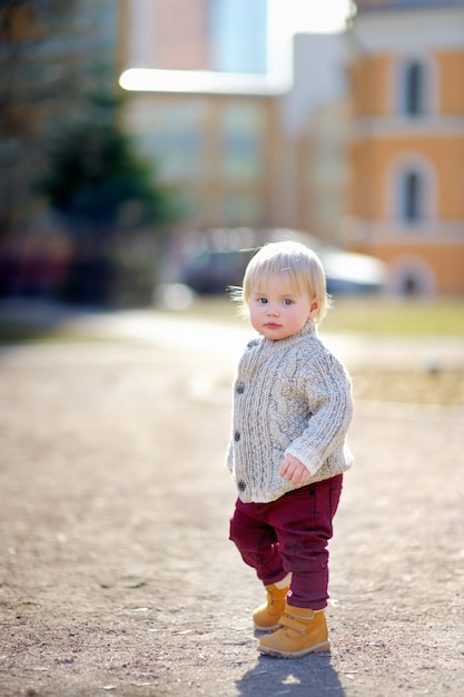 Beautiful toddler boy walking outdoors at the warm spring day