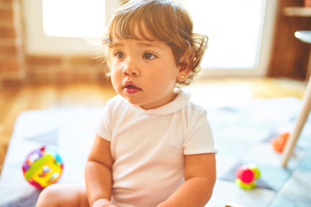 Beautiful toddler child girl playing with toys on the carpet