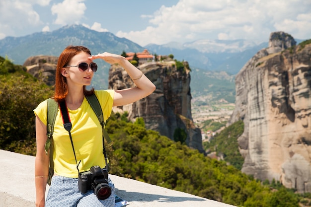 Beautiful tourist in Greece with the Meteora Monasteries in the background