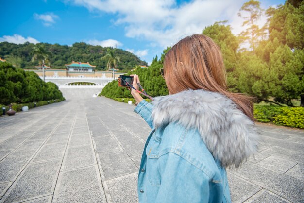 台北、台湾の有名な場所で美しい観光客の女性が撮影しています。