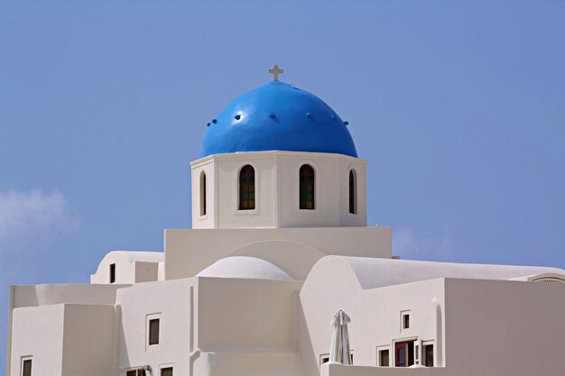 Beautiful traditional s white house with blue domes in Village of Oia Santorini Greece blue sky