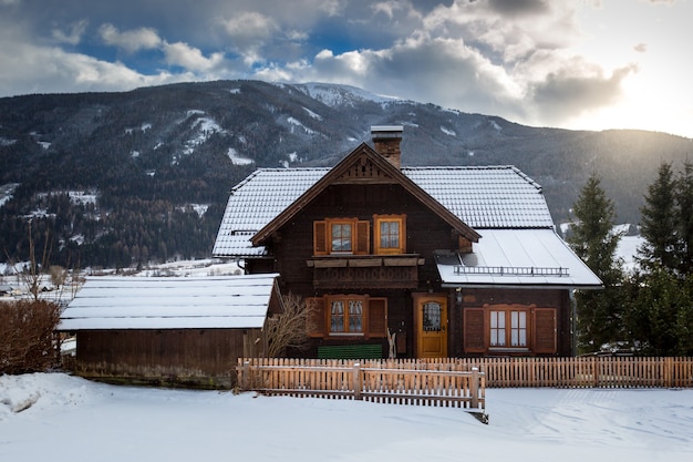 Beautiful traditional wooden house in Alps covered with snow