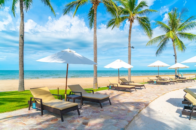 Beautiful tropical beach and sea with umbrella and chair around swimming pool in hotel resort