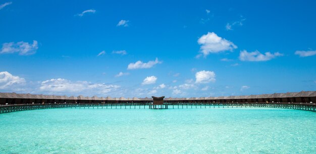 Beautiful tropical Maldives island with beach. Sea with water bungalows