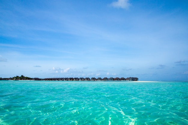 Beautiful tropical Maldives island with beach. Sea with water bungalows