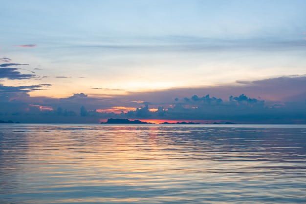 美しい熱帯ピンク青い海の夕日と黄色の雲の背景