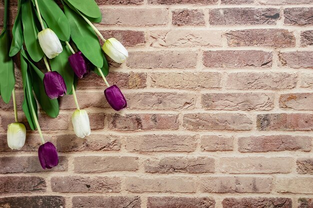 Beautiful tulips on brick wall background Lovely greeting card with tulips for Mothers day