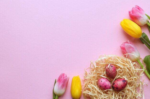 Beautiful tulips and nest with colored quail eggs