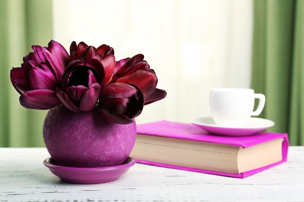 Beautiful tulips in pot with book