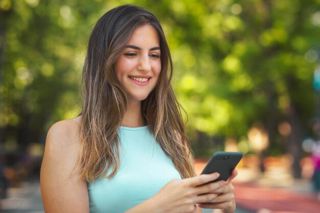 Beautiful Turkish young woman typing a message via her smart phone