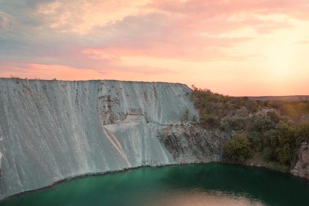 Beautiful turquoise lake with granite banks at sunset aerial view