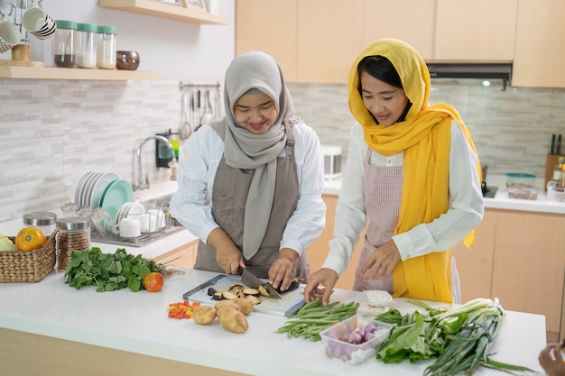 美しい2人のイスラム教徒の女性が一緒に夕食を作るのを楽しむ