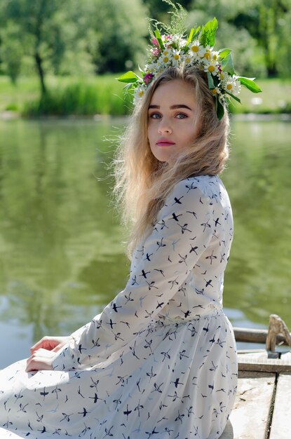 Beautiful ukrainian girl sits by the river