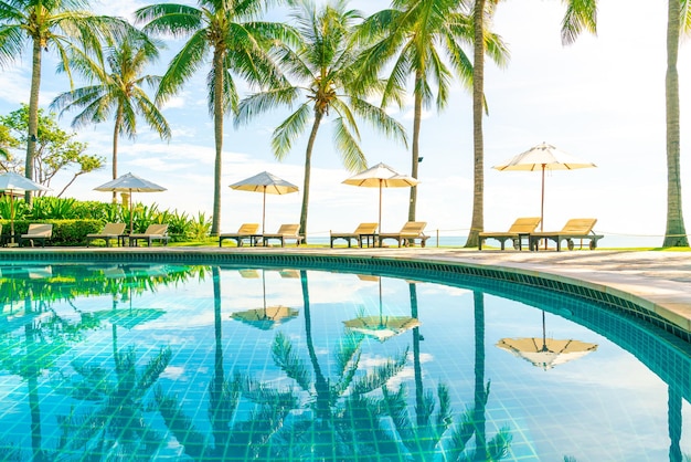 Bellissimo ombrellone e sedia intorno alla piscina nel concetto di vacanza in hotel e resort