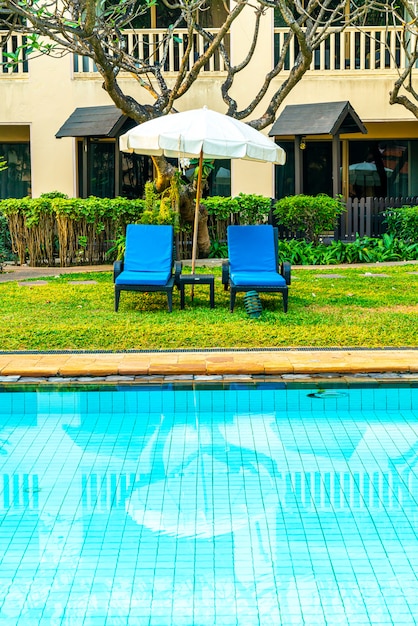 ホテルとリゾートのプールの周りの美しい傘と椅子