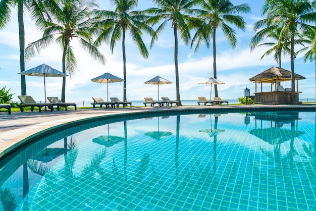 Beautiful umbrella and chair around swimming pool in hotel and resort