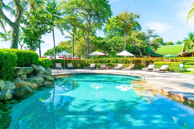 Foto bellissimo ombrellone e sedia intorno alla piscina in hotel e resort