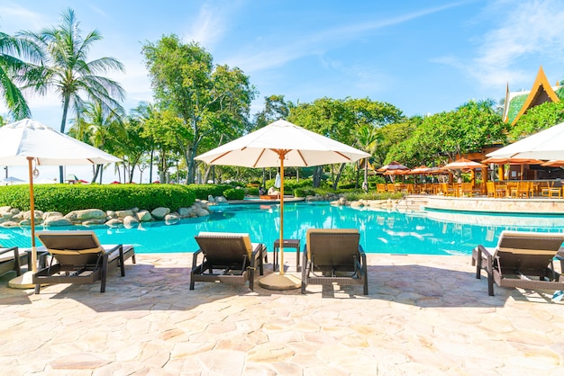 Beautiful umbrella and chair around swimming pool in hotel and resort