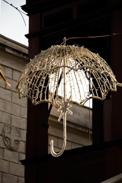 Beautiful umbrella of golden color hanging in the street for decoration