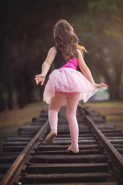 Фото Красивая несовершеннолетняя девочка, играющая в парке в костюме балерины, детский день