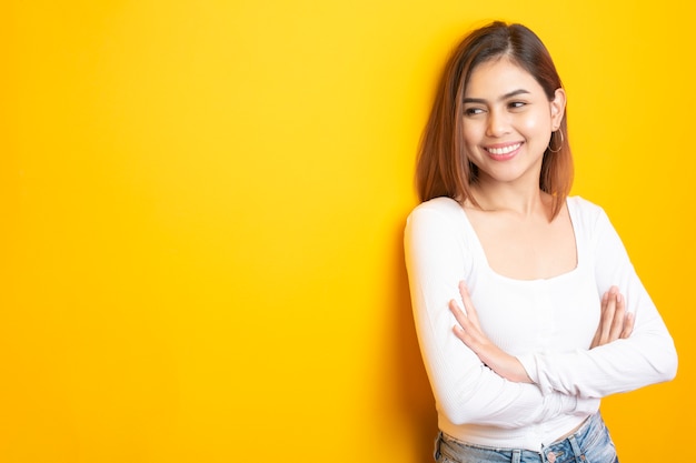 Beautiful university student is smiling on yellow 