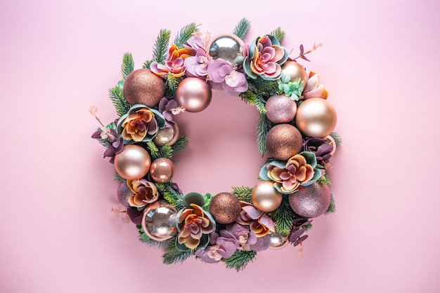 Beautiful unusual Christmas wreath decoration on pink . flat lay