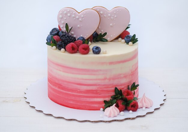 Beautiful valentine cake decorated with fresh raspberries, blackberries and blueberries,