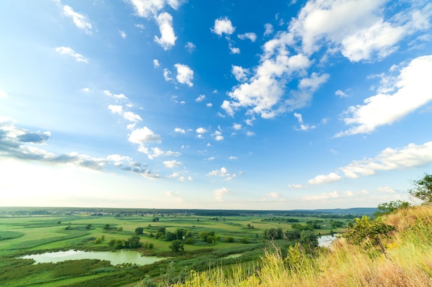 Foto una bellissima valle con un cielo blu fiume con grandi nuvole e sole splendente antenna 4k uhd