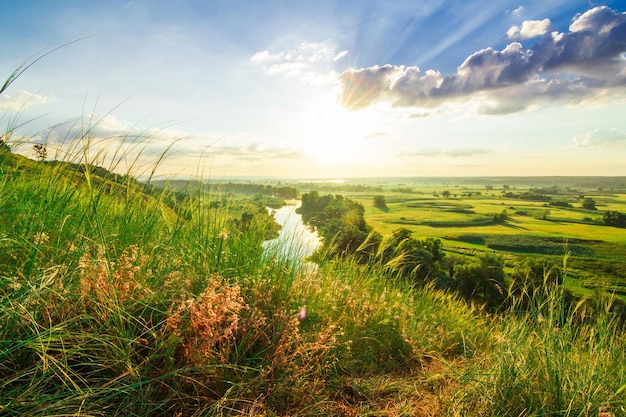 A beautiful valley with a river blue sky with large clouds and bright sun Aerial